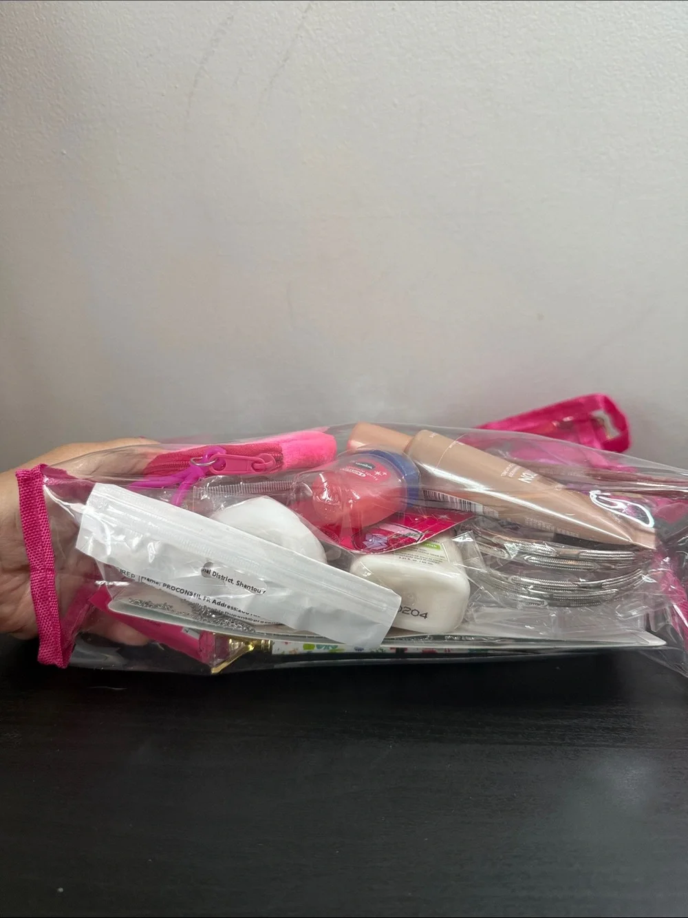 Clear Cosmetic Pouch with Hot Pink Trim and Pom Charm filled with goodies